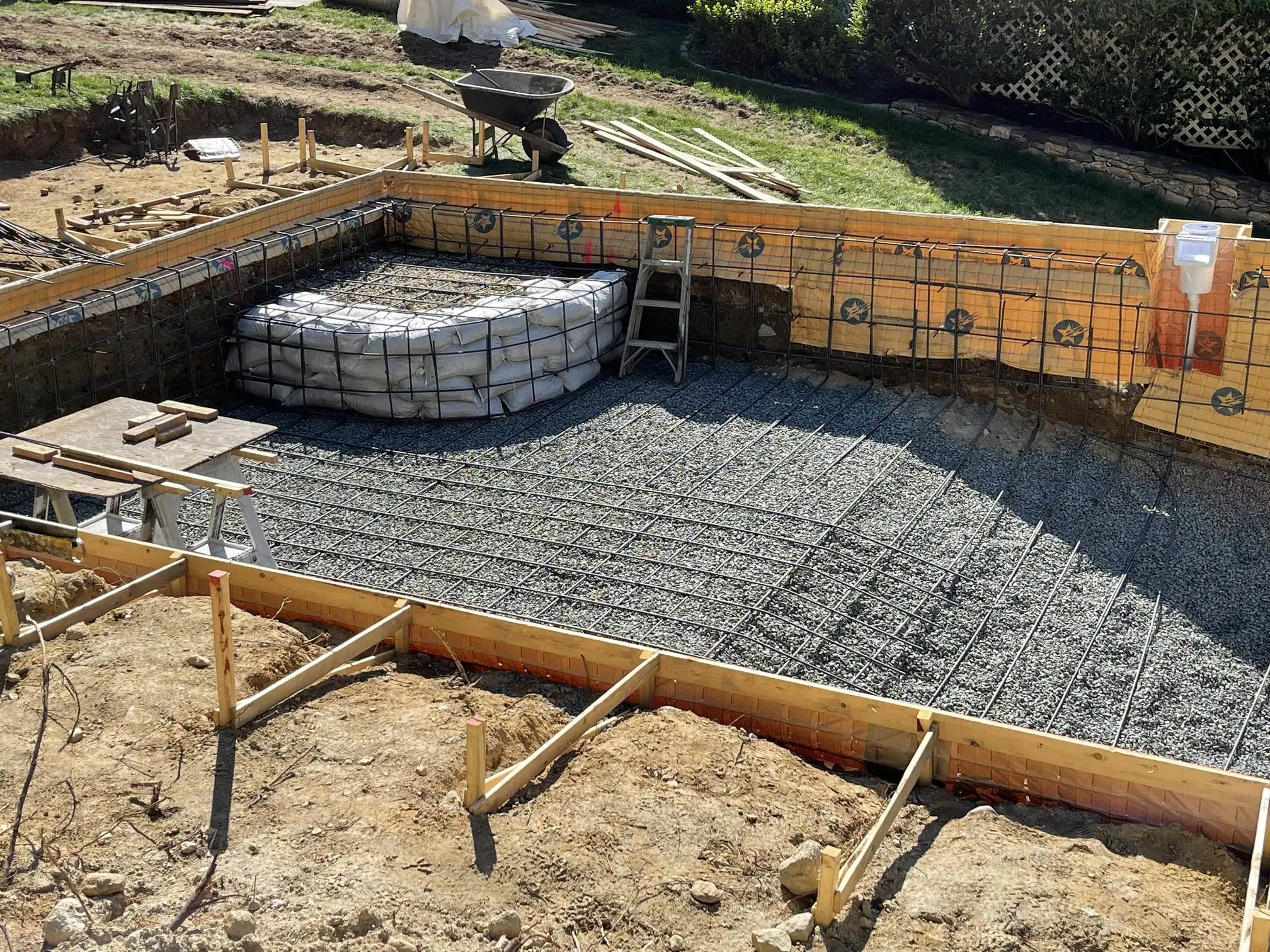 A newly dug swimming pool with rebar reinforcement in place, ready for concrete.