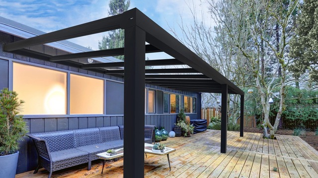 Finding Your Perfect Fit: Choosing the Right Pergola Installer 1 A modern patio with a new wood deck, a black metal pergola, and a sleek outdoor sofa